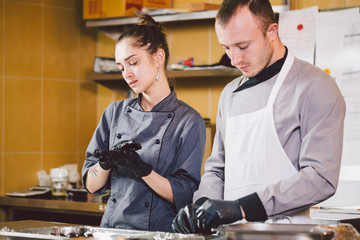 Cheerful Experienced Man And Woman Staff. Profession preparation confectionery products. Caucasian man and woman two employees colleague teamwork pastry chef. Theme cooking chocolates truffle