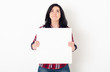 A beautiful young student girl with a pensive facial expression looks up and holds a white square blank sheet in her hands. White background.