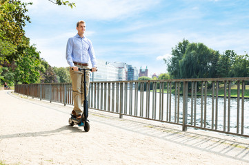 Wall Mural - Young Man Riding An Electric Scooter