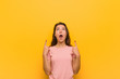 © Asier - Young european woman isolated over yellow background pointing upside with opened mouth.