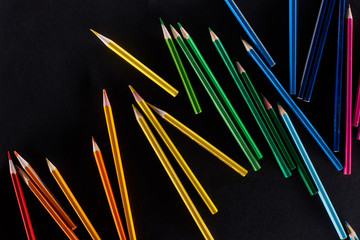 scattered sharpened color pencils isolated on black