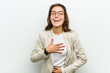© Asier - Young european business woman laughs happily and has fun keeping her hands on stomach.
