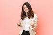© Asier - Young brunette business woman against a pink background raising both thumbs up, smiling and confident.