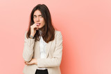 Fototapeta Konie - Young brunette business woman against a pink background relaxed thinking about something looking at a copy space.