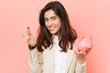 © Asier - Young caucasian woman holding a piggy bank