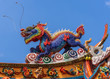 Manila, Philippines - March 5, 2019: Chinese Cemetery in Santa Cruz part of town. Closeup of dragon at colorful and extensively decorated top of main gate to temple and ceremonial hall. Blue sky.