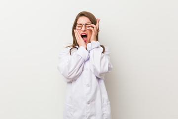 Wall Mural - Young doctor woman against a white wall whining and crying disconsolately.