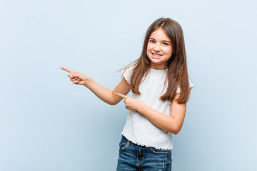 Wall Mural - Cute girl excited pointing with forefingers away.