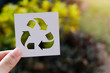 © panadda - Hand holding recycling symbol created with paper cut and landscape on background, Concept of environmental conservation and protection.