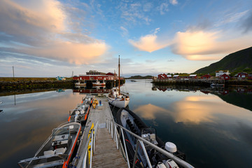 Sticker - Fishing boat and red village Reflecting the water in the evening at Ballstad, Northern Norway, Rorbu is the traditional home of Norwegian fishermen.