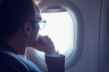 Man looking through a modern airplane window.