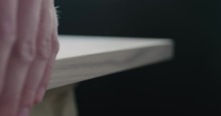 Poster - Slow motion woodworker touching untreated black walnut board