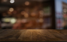 Empty Dark Wooden Table In Front Of Abstract Blurred Bokeh Background Of Restaurant . Can Be Used For Display Or Montage Your Products.Mock Up For Space.