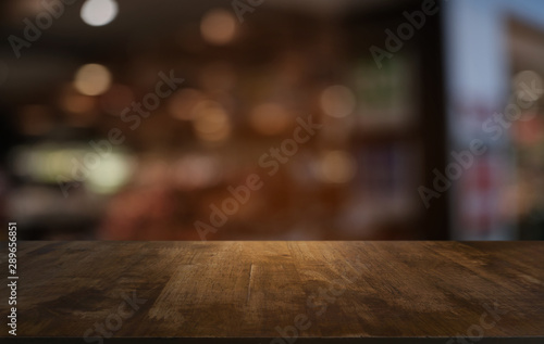 Fotografía Empty dark wooden table in front of abstract blurred bokeh background of restaurant