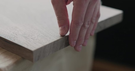 Poster - Slow motion woodworker hand sanding walnut board with sand block