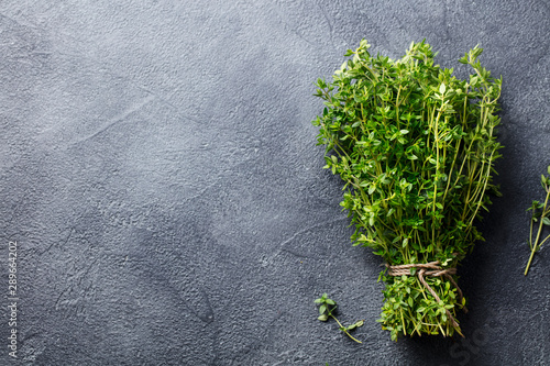 Fotografía Fresh thyme bunch on slate background. Top view. Copy space.