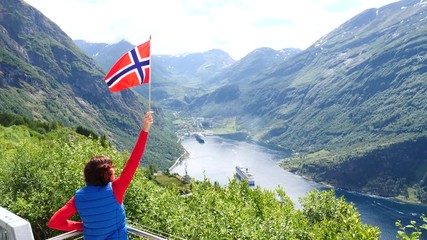 Poster - Tourist woman holding norwegian flag, enjoying Geirangerfjord fjord view with large cruise ship. View from Ornesvingen viewpoint. Tourism, travel for relaxation and sightseeing