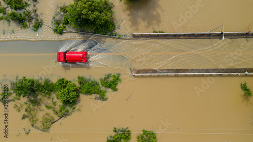 Fotografía Aerial top view of Flooded the village and Country road with a red car, View fro
