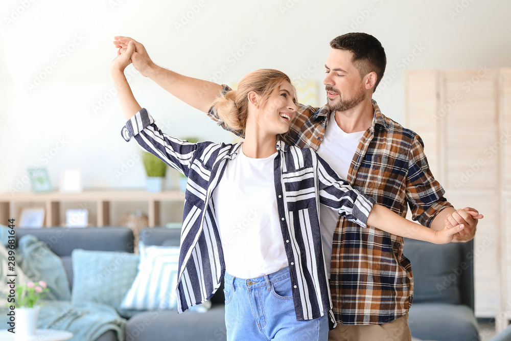 Happy dancing couple at home