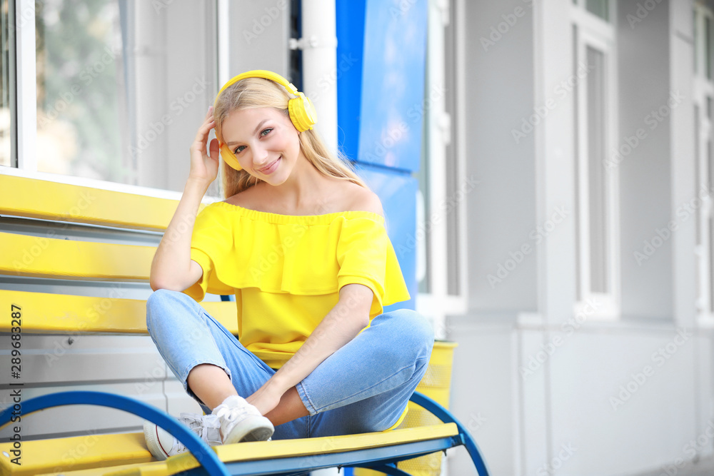 Beautiful young woman listening to music outdoors Stock Photo | Adobe Stock
