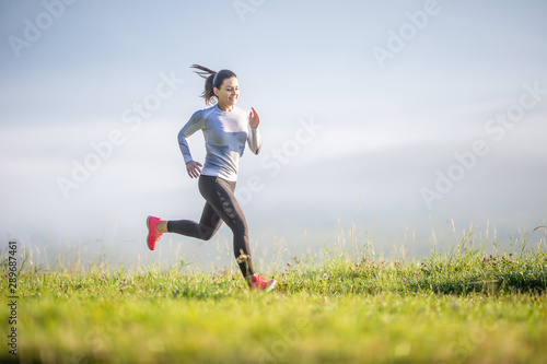 Fotografía Young sporty woman running in nature