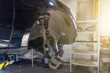 Canvas Print - A close-up on the brake system of a car with pads, discs, a caliper on a lift in a vehicle repair workshop. Auto service industry.