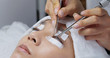© leungchopan - Beauty professional procedures eyelash extension on woman eyes