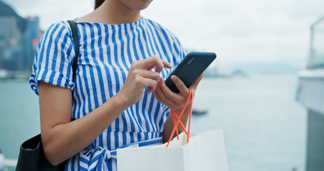 Wall Mural - Woman use of cellphone with shopping bag