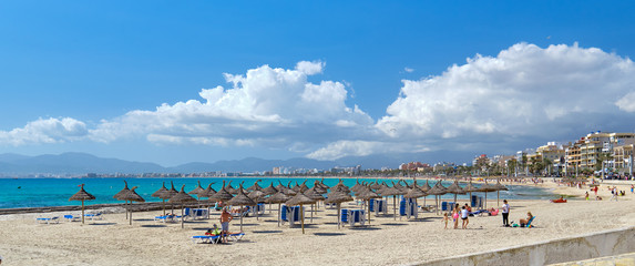 Panoramic image beach with parasols sunbeds of El Arenal resort town, Majorca, Spain