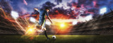 Fototapeta Sport - Soccer players in action on sunset stadium background