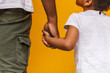 Little african girl holding her daddy hand and looking at him