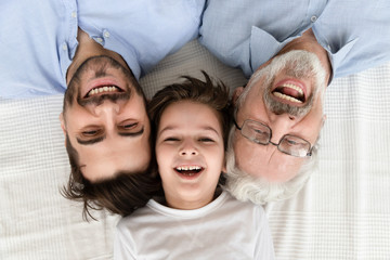 Wall Mural - Happy three generation family lying in row, portrait, closeup view