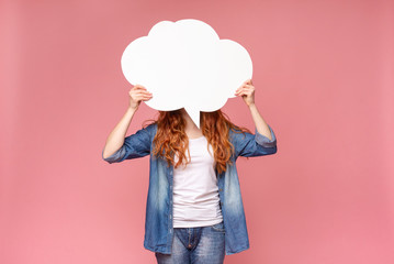 Wall Mural - Redhead female hiding her face behind blank white speech bubble