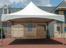 White Event Tent Canopy Erected On Brick Patio.