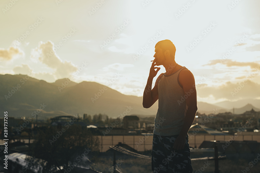 cigarette sunset man looking at sunset and smoking a cigarette Stock Photo