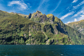 Wall Mural - Rocks and waterfall of famous Milford Sound, New Zealand, picture taken from cruise ferry