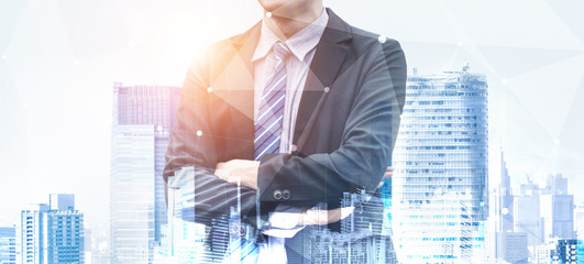 Wall Mural - Double Exposure Image of Business Person on modern city background. Future business and communication technology concept. Surreal futuristic cityscape and abstract multiple exposure graphic interface.