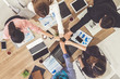 © InfiniteFlow - Businessmen and businesswomen joining hands in group meeting at multicultural office room showing teamwork, support and unity in business. Diversity workplace and corporate people working concept.