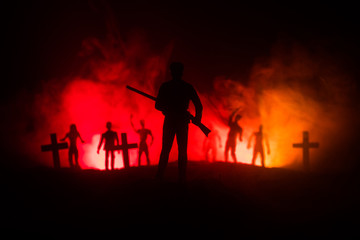 Silhouettes crowd of hungry zombies and old windmill on hill against dark foggy toned sky. Silhouettes of scary zombies walking at night. Horror Concept