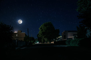 Wall Mural - full moon over quite village at night. beautiful night landscape of old town street with lights. rus