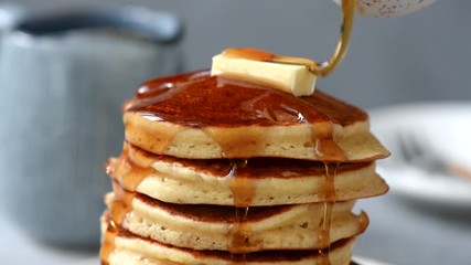 Wall Mural - Pancakes with butter and maple syrup. Pouring syrup on stack of fluffy buttermilk pancakes, american style breakfast