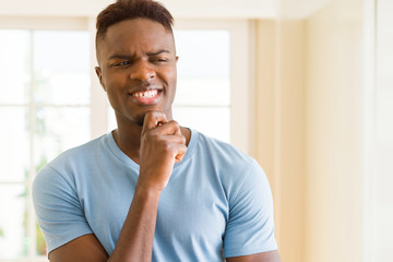 Canvas Print - Handsome young african man thinking and questioning with pensive face, hand on chin wondering about a doubt