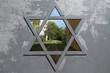 Blick durch ein Tor mit Davidstern auf die ehemalige Judengasse hinter dem jüdischen Friedhof an der Schönhauser Allee in Berlin-Prenzlauer Berg