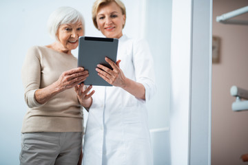 Wall Mural - Happy woman is looking on digital tablet