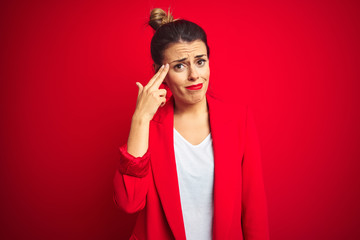 Canvas Print - Young beautiful business woman standing over red isolated background Shooting and killing oneself pointing hand and fingers to head like gun, suicide gesture.