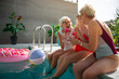 © Yakobchuk Olena - Cheerful old women chatting and enjoying drinks at the pool