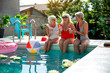 © Yakobchuk Olena - Cheerful senior women enjoying drinks at the pool