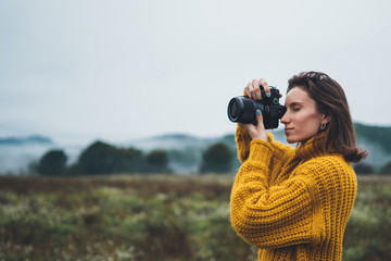 Wall Mural - photographer traveler take photo on video camera closeup on background autumn froggy mountain, tourist shooting nature mist landscape outdoor, hobby concept copy space mockup