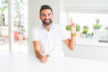 Sticker - Handsome hispanic man casual white t-shirt at home smiling with happy face winking at the camera doing victory sign. Number two.