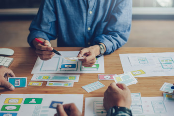 Team of website designers who are creative and planning to develop an application on the mobile phone in the office.